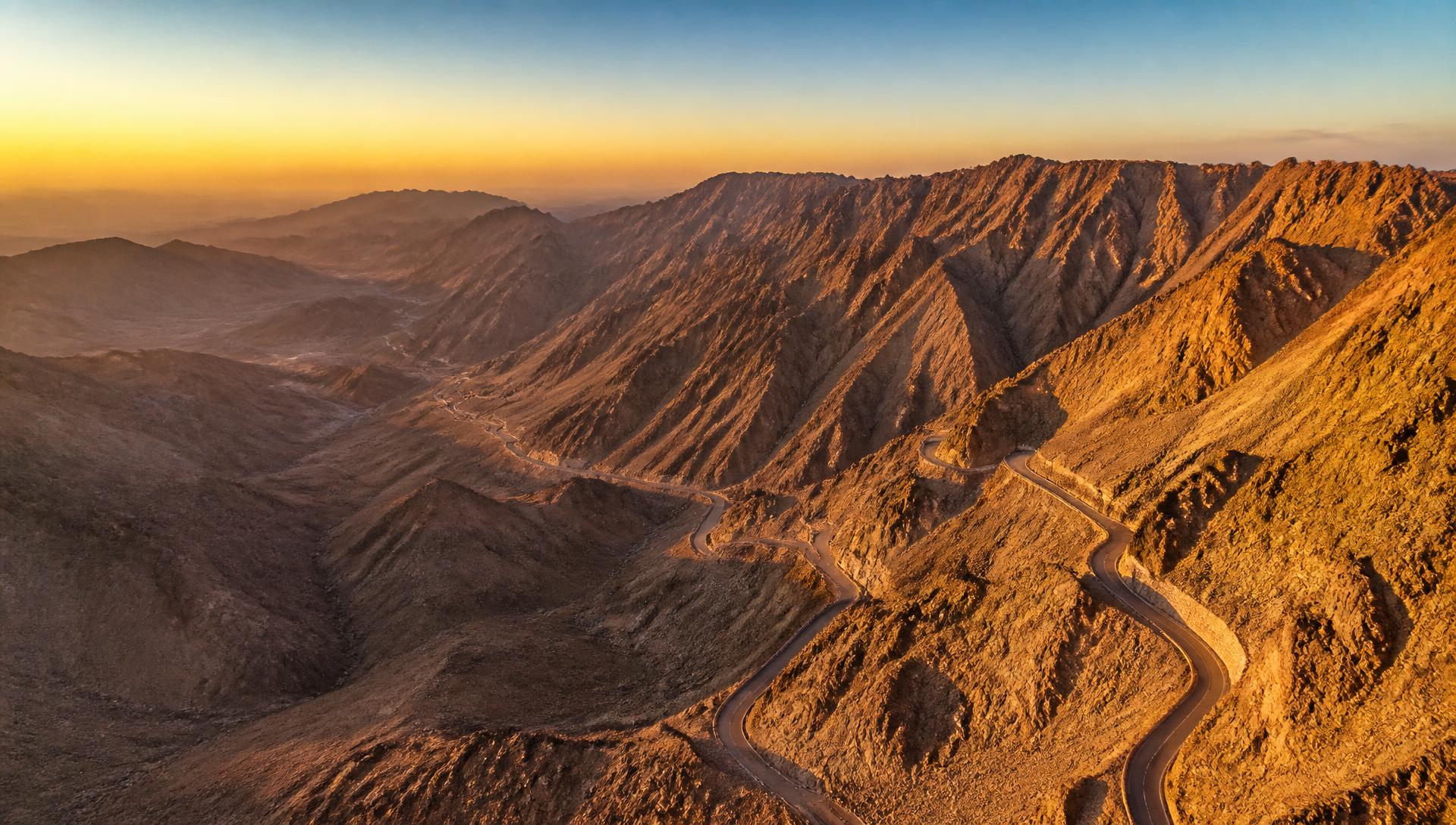 Aerial view of rugged Saudi Arabian desert mountains at golden hour